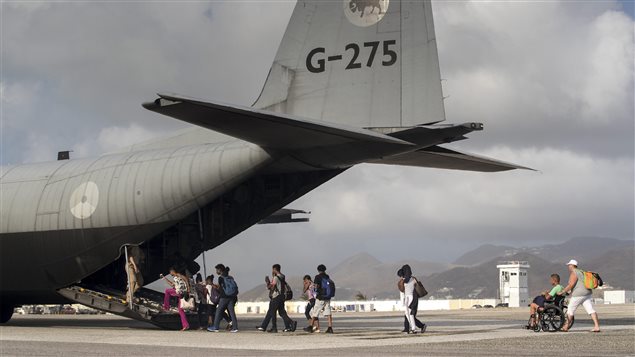 This photo provided by the Dutch Defence Ministry on Sunday, Sept. 10, 2017 shows people walking into a military plane on St. Maarten, after the passage of Hurricane Irma.