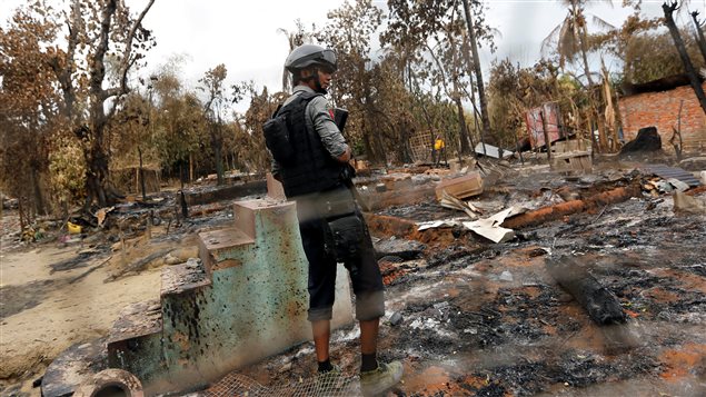 A police officer stands in a house that was burnt down during the days of violence in Maungdaw, Myanmar August 30, 2017.