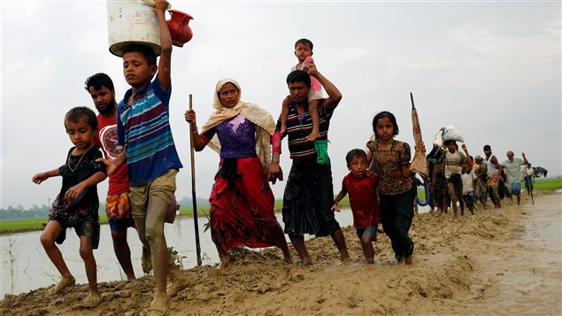 Rohingya refugees walk on the muddy path after crossing the Bangladesh-Myanmar border in Teknaf, Bangladesh, September 3, 2017. 