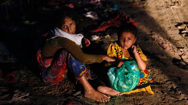 Rohingya refugee woman waits for aid with her daughter along a road in Cox’s Bazar, Bangladesh September 18, 2017.