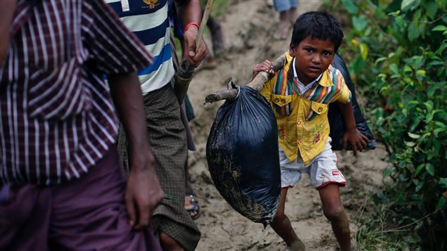 A Rohingya refugee boy carries his belongings as he walks to a makeshift camp in Cox’s Bazar, Bangladesh September 18, 2017.