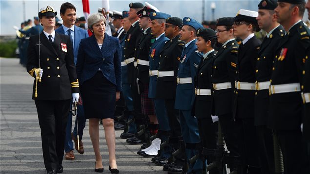 British Prime Minister Theresa May takes part in a troop inspection as she is greeted by Prime Minister Justin Trudeau to Parliament Hill in Ottawa on Monday, Sept. 18, 2017. 