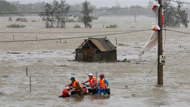 People recover motorbikes from a flooded fields while the Doksuri typhoon hits in Ha Tinh province, Vietnam September 15, 2017. While major hurricanes have struck the Caribbean, major and deadly typhoons have been tearing through Asia, adding impetus to the need for action on climate issues