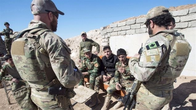 Canadian special forces soldiers, left and right, speak with Peshmerga fighters at an observation post, in northern Iraq earlier this year. They will soon be joined in the country by a dozen Canadian army combat engineers who will train local security forces to detect and defuse roadside bombs. 