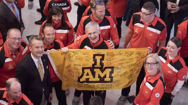 Members of Team Canada, which has 90 athletes on its roster, hold a flag signed by Members of Parliament as they pose for a photo with Minister of Veterans Affairs Seamus O'Regan during a welcoming ceremony at Rideau Hall for athletes competing at the 2017 Toronto Invictus Games, in Ottawa on Wednesday. 