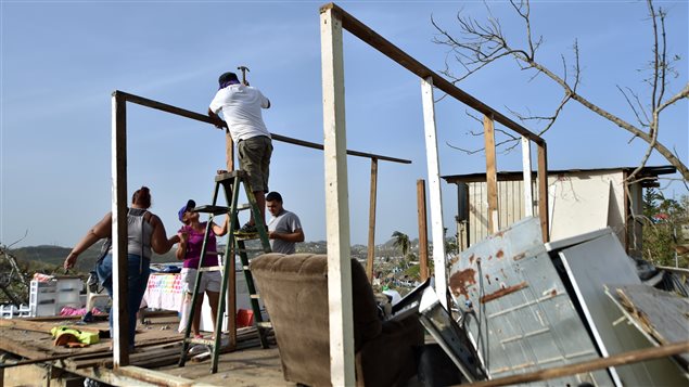 Puertorriqueños reconstruyendo sus casas después del paso del huracán María.
