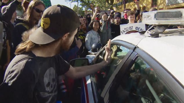 A large crowd of counter-protesters surrounded a police car demanding an arrested anti-fascist protester be set free.