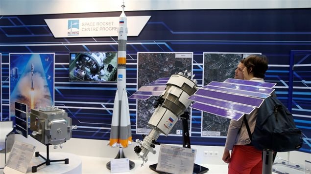 Visitors watch the booth of Russian Federal Space Agency Roscosmos displaying models of satellites at the ILA Berlin Air Show in Schoenefeld, south of Berlin, Germany, June 1, 2016. (Fabrizio Bensch/Reuters)