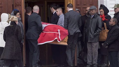 The flag-draped coffin of Lionel Desmond is carried into St. Peter's Church in Tracadie, N.S. on Jan. 11. Desmond, a former infantry corporal living in Nova Scotia who was suffering from post-traumatic stress disorder, shot and killed his wife Shanna, 10-year-old daughter Aaliyah and his mother Brenda. He then killed himself.
