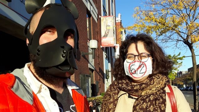 Quebequenses se cubren el rostro en una parada de autobús en Montreal en protesta contra la Ley 62. 