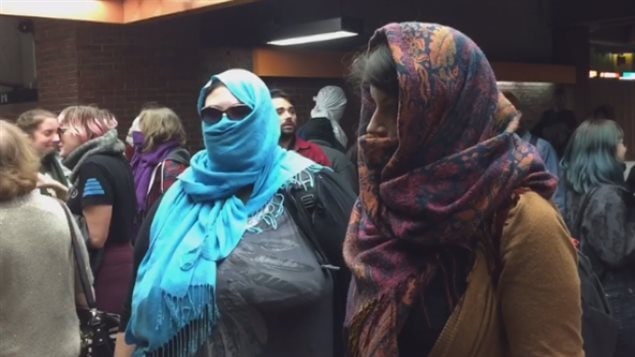 Non-Muslims in Montreal covered their faces and entered the subway to protest a new law that bans face-coverings for anyone accessing or providing public services.