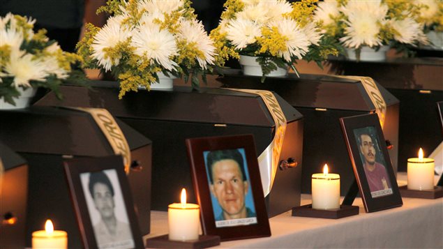 Candles and portraits stand in front of coffins containing remains of 14 people who were killed during armed conflict by paramilitary fighters and rebel fighters, during a ceremony in Medellin, Colombia. November 17, 2016.