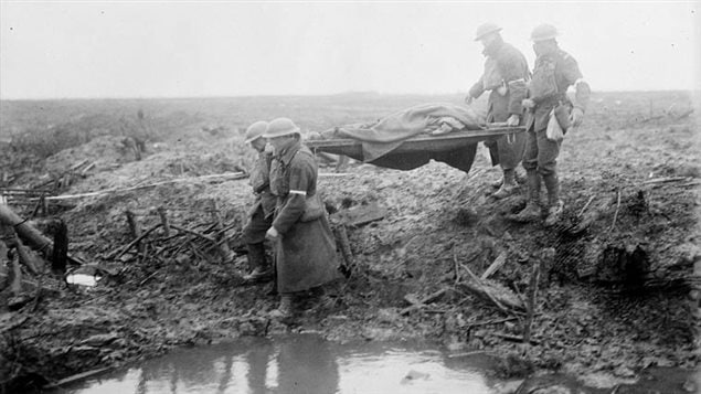 Carrying wounded to an aid post. Just walking through the field was dangerous as a mistep near the slippery mud in the deep water-filled  craters could lead to drowning.