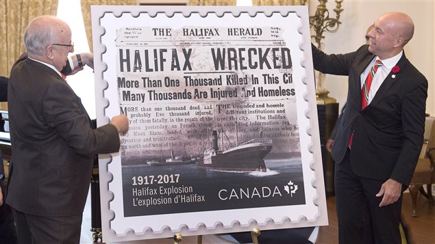 El Gobernador general de Nueva Escocia, Arthur J. LeBlanc (izq.) y Andy Fillmore, diputado federal de Halifax, presentan la estampilla. 