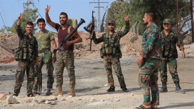 Soldados del ejército sirio hacen la señal de la victoria.
