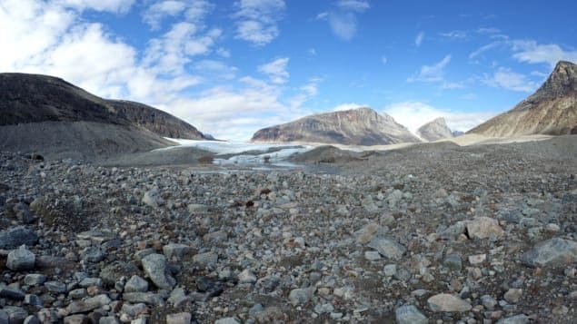 Sur ce glacier situé dans le fjord Sam Ford, on peut voir les moraines, cet amas de roches entraînées par le mouvement du glacier. En regardant les falaises, on peut imaginer la taille du glacier avant. La ligne est encore bien visible, séparant les falaises entre le clair et le foncé. Le glacier remplissait toute la vallée. Photo : Radio-Canada/Marie-Laure Josselin