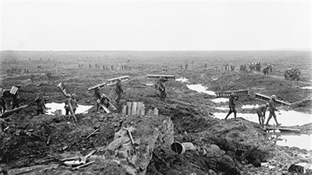 Canadian soldiers carry *trench mats* or *duck boards* across the blasted fields to help movement over the treacherous mud