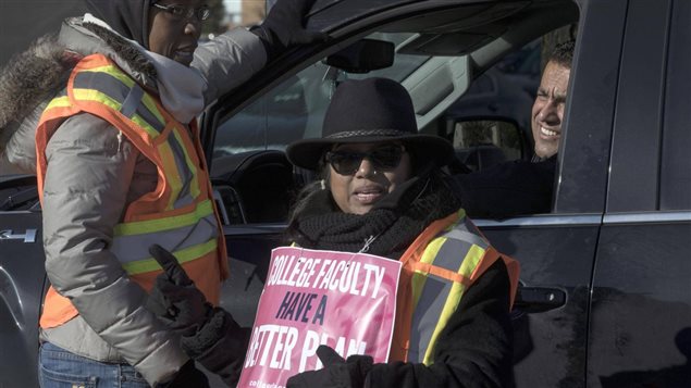 Faculty members delay cars passing through a picket line at a Humber College campus in Toronto on Nov. 8, 2017.