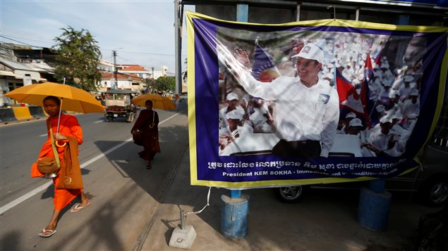 Buddhist monks walk past a banner of opposition leader and President of the Cambodia National Rescue Party (CNRP) Kem Sokha at the party’s headquarters in Phnom Penh, Cambodia, November 17, 2017.