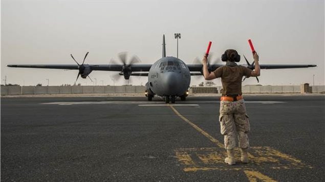  A technician guides a CC-130J Hercules as it returns from its first mission with Operation IMPACT in Kuwait on July 12, 2017.