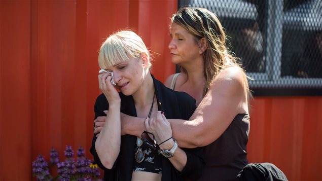 A woman is consoled while wiping away tears during a memorial service to remember those who have died in the province as a result of the drug overdose crisis, on International Overdose Awareness Day in the Downtown Eastside of Vancouver, B.C., on Thursday August 31, 2017. 