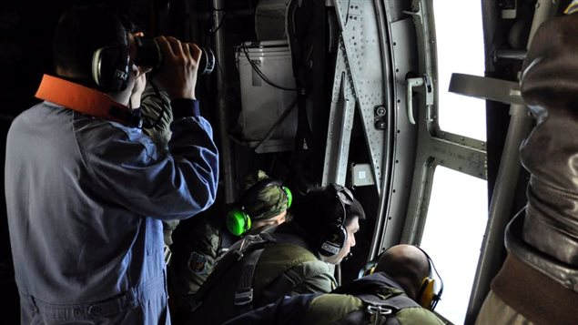Members of the Argentine Navy look down at the sea from an airplane during a flight to search for the ARA San Juan submarine missing at sea, Argentina November 22, 2017.