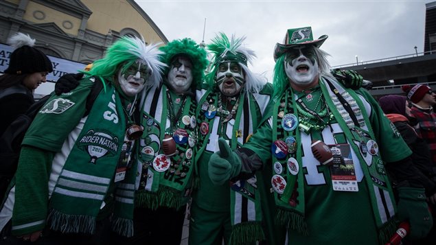 Fans show up in a variety of wierd and wonderful expressions of support for their teams, but there is almost never anythiing but fun times between opposing fans. Here fans in STampeder green show their support.