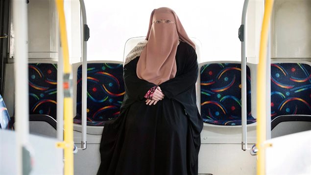 Warda Naili poses for a photograph on a city bus in Montreal on October 21, 2017. The Quebec woman, a convert to Islam, said she decided to cover her face out of a desire to practice her faith more authentically and to protect her modesty. 