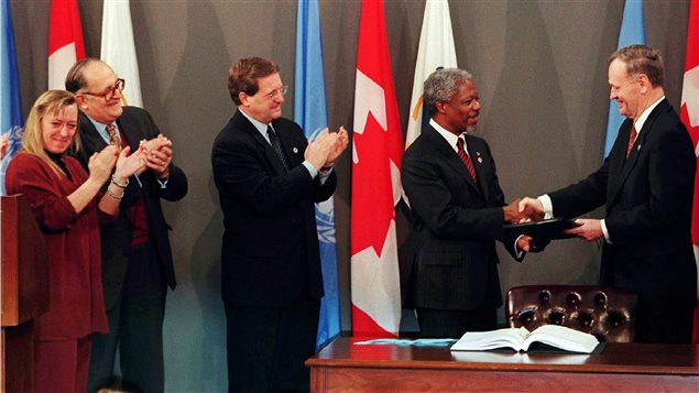 Canadian Prime Minister Jean Chretien hands over the signed Global Ban on Landmines treaty to United Nations Secretary General Kofi Annan while Foreign Affairs minister Lloyd Axworthy (ctr), president of the International Committee of the Red Cross Cornelio Sommaruga and Nobel Prize laureate Jody Williams applaud in Ottawa on Dec. 3, 1997.