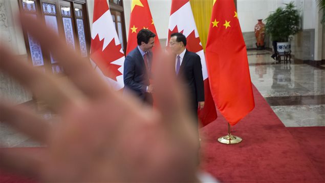 A security guard attempts to block a photographer as a picture is taken of Prime Minister Justin Trudeau being greeted by Chinese Premier Li Keqiang at the Great Hall of the People in Beijing, China on Monday, Dec. 4, 2017. The incident happened following a difference of opinion between Canadian and Chinese government staff regarding the number of foreign journalist and prime ministerial staff allowed to witness the photo opportunity.