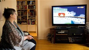 A participant takes part in the study at her home by playing a video game.