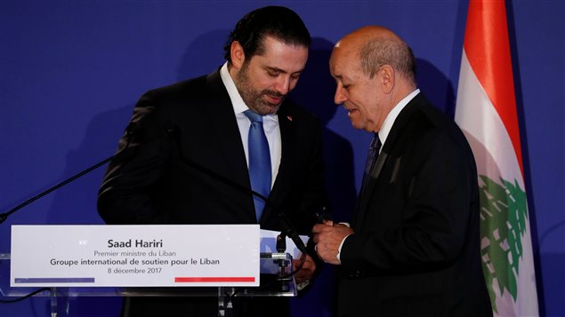 رئيس الحكومة اللبنانية سعد الحريري (إلى اليسار) متحدثاً مع وزير الخارجية الفرنسي جان إيف لو دريان في اجتماع "المجموعة الدولية لدعم لبنان" اليوم في باريس ويبدو العلم اللبناني في الصورة.