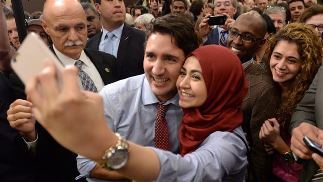 Prime Minister-designate Justin Trudeau poses for a selfie with a supporter as he takes part in a welcome rally in Ottawa on Tuesday, Oct. 20, 2015.