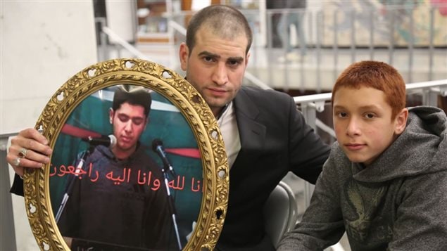 والد الضحية والشقيق الأصغر يحملان صورة يوسف