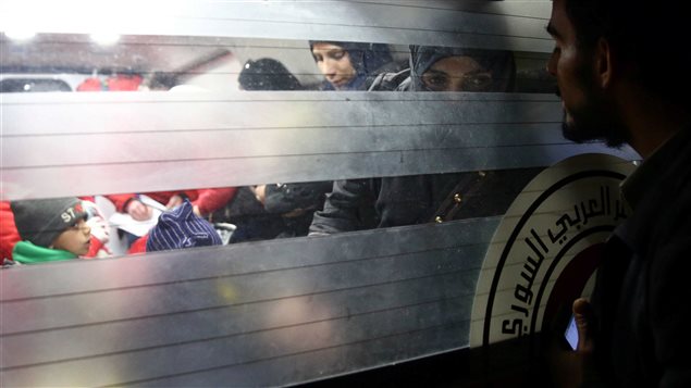 نساء وأطفالهن في سيارة إسعاف خلال عملية الإجلاء الطبية من مدينة دوما في غوطة دمشق الشرقية أمس