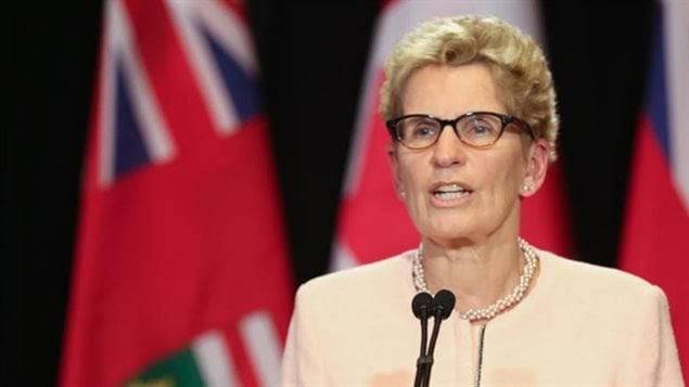 Ontario Premier Kathleen Wynne has increased the minimum wage to $14 this year, and $15 next year. She says moves by business to recoup profits by cutting employee benefits as unfair and the action of bullies.