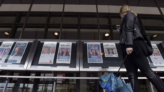 A woman views the front pages of newspapers on display outside the Newseum in Washington on November 9, 2016. Newsprint is the latest Canadian product to be hit with preliminary countervailing duties from the United States. 