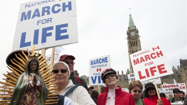 March 2010: Anti-abortion activists march in front of Parliament Hill in Ottawa. Pro-life groups are clearly targetted by the new law as being excluded from grants for summer jobs.