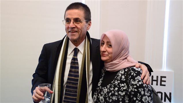 Hassan Diab stands with his wife, Rania Tfaily, as he speaks with reporters in Ottawa on Wednesday. 