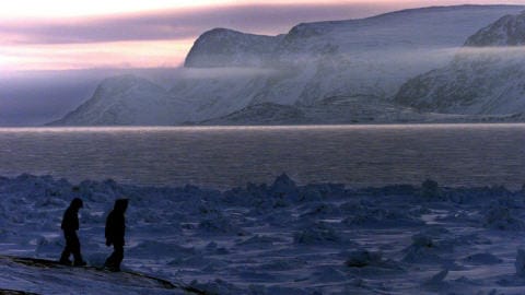 Deux enfants se promènent sur la rive à Pangnirtung au Nunavut