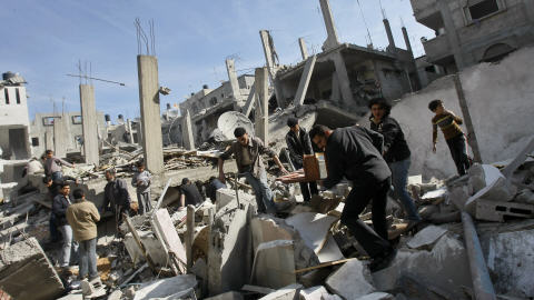 Des Palestiniens fouillent les décombres d'un immeuble détruit par l'armée israélienne dans le quartier Sheikh Radwan de la ville de Gaza mercredi.