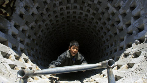 Un garçon pose dans l'entrée d'un tunnel détruit par les bombes israéliennes