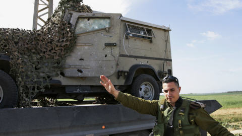 L'armée israélienne déplace une jeep endommagée par l'attaque de mardi matin.