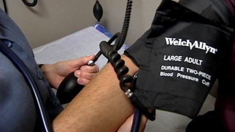 Un médecin mesure la tension artérielle d'un patient.