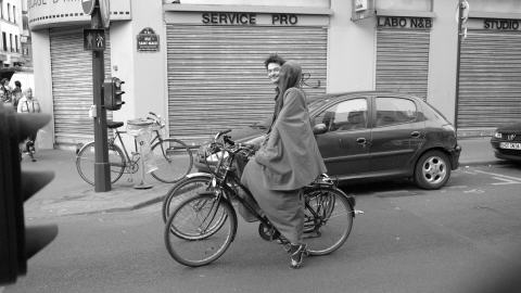 Une femme en burqa se promène à vélo dans les rues de Paris