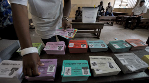 Un électeur gabonais fait son choix parmi les bulletins de vote, dimanche.