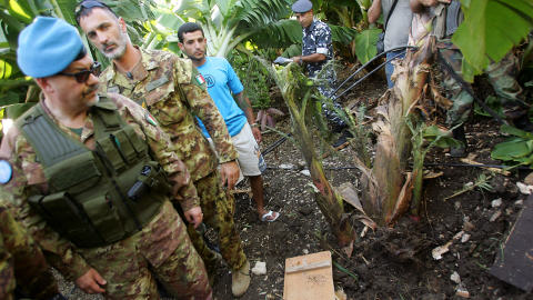 Des soldats italiens de l'ONU et des membres des forces de sécurité libanaises inspectent le site d'où ont été tirées les roquettes vers Israël.