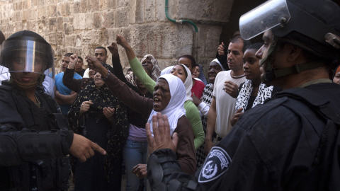 Des femmes palestiniennes crient à des policiers lors d'une effarouchée à Jérusalem.