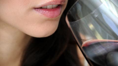 Une femme boit du vin
