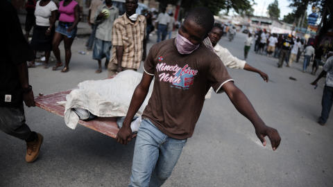 Des Haïtiens ramassent des cadavres dans les rues de Port-au-Prince